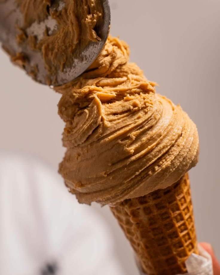 Cucurucho de helado de dulce de leche servido con la cuchara